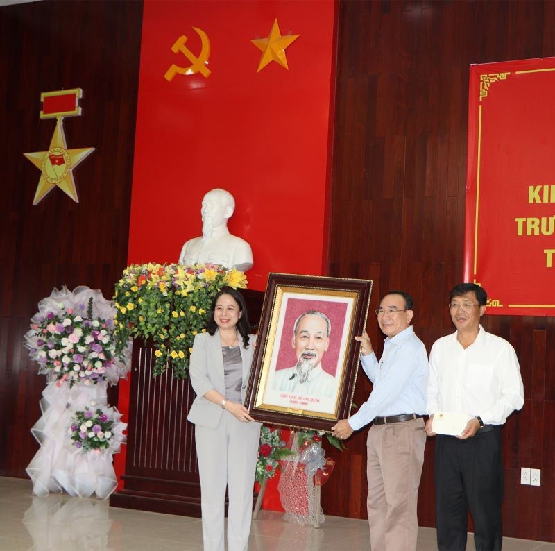 Vice President Vo Thi Anh Xuan presents a portrait of President Ho Chi Minh to leaders of Tinh Bien Township. 