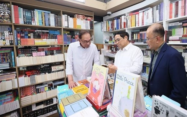 Prime Minister Pham Minh Chinh (centre) and his Malaysian counterpart Anwar Ibrahim (left) are at a store on Hanoi's book street. (Photo: VNA)