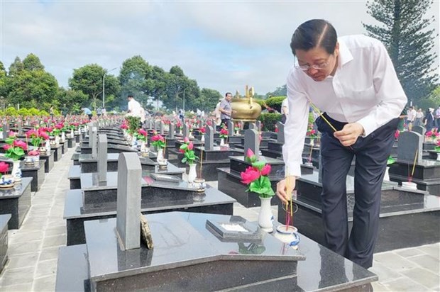 Chairman of the Party Central Committee’s Commission for Internal Affairs Phan Dinh Trac offers incense at martyrs' tombs at the Dak Lak martyrs cemetery. (Photo: VNA)