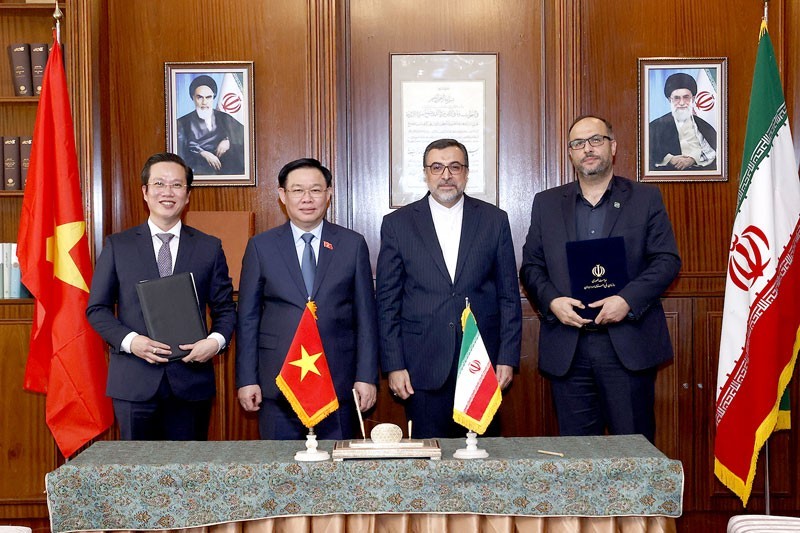 NA Chairman Vuong Dinh Hue and Deputy Foreign Minister of Iran Mohammad Hassan Sheikholeslami witness the signing ceremony of the cooperation agreement. (Photo: Vu Tu Quyen)