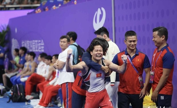 Khanh Phong celebrates with members of the coaching staff of the gymnastics squad. (Photo: VNA)