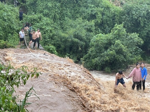 The rescue team use a rope to rescue the children trapped in the middle of the stream when the floodwaters appear (Photo: baogialai.com.vn) 