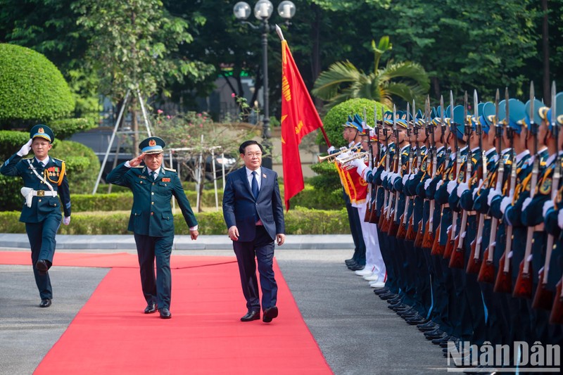 NA Chairman Vuong Dinh Hue reviews an honour guard of the ADAF. 