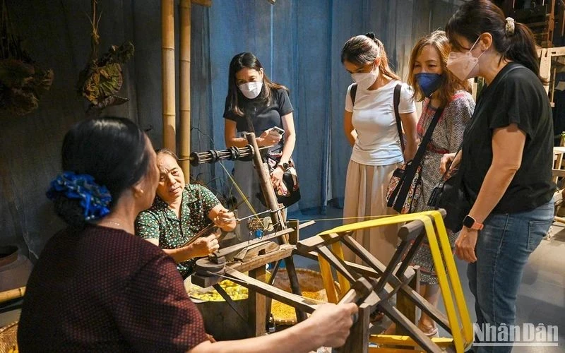 Foreign tourists learn about traditional silk weaving of Vietnam. (Photo: DUY DANG)