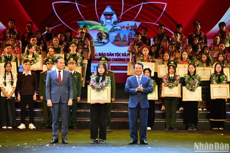 Deputy PM Tran Luu Quang and Minister-Chairman Hau A Lenh present certificates of merit to outstanding ethnic minority students and youths. 