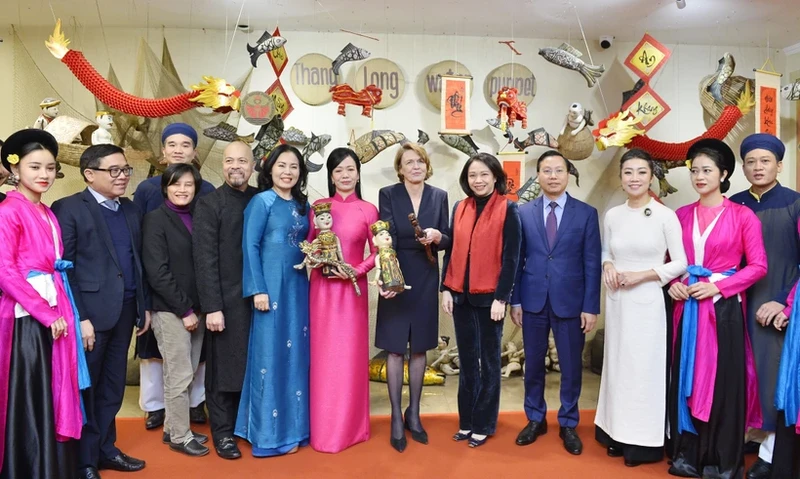 The spouses of the Vietnamese and German Presidents pose for a photo with artists at the theatre (Photo: VNA)