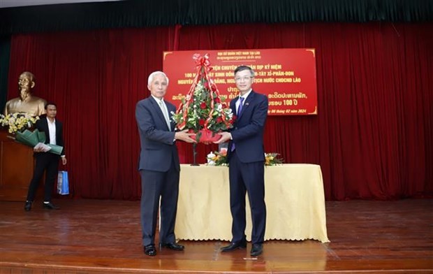 Khamphan Pheuyavong, Secretary of the LPRP Central Committee and head of its Commission for Propaganda and Training (L), presents a basket of flowers to Counselor of the Vietnamese Embassy in Laos Phan Minh Chien on the occasion of Vietnam's Lunar New Year. (Photo: VNA)