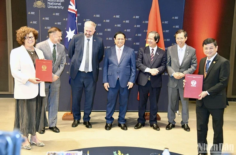Prime Minister Pham Minh Chinh (fourth, left) witnesses the exchange of cooperation documents between Vietnamese and Australian universities. (Photo: VNA) 