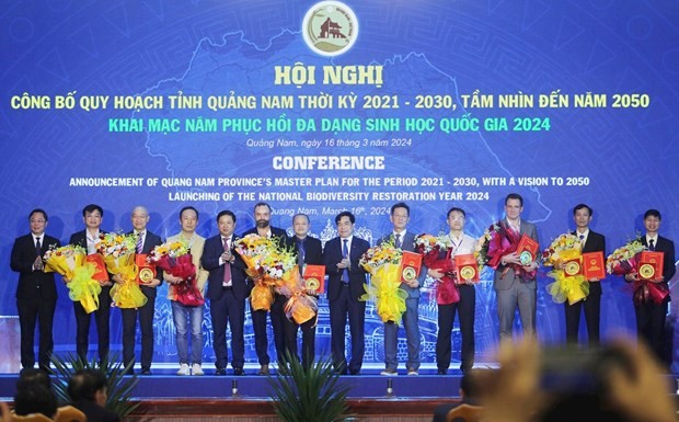 Leaders of Quang Nam province present investment policy approval decisions to businesses at the conference. (Photo: baoquangnam.vn) 