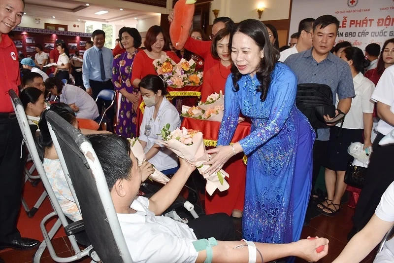 Acting President Vo Thi Anh Xuan presents flowers to blood donors in response to the 2024 National Humanitarian Month in Dien Bien.
