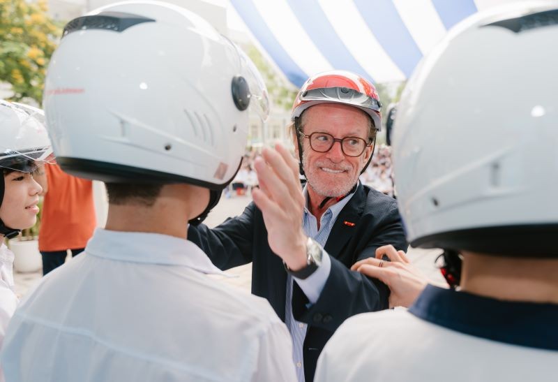 President of AIP Foundation Greig Craft presents helmets to students.