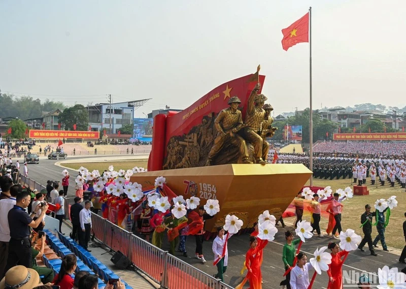 A float carrying sculptures of soldiers dragging artillery with the text “Determined to fight, determined to win.”