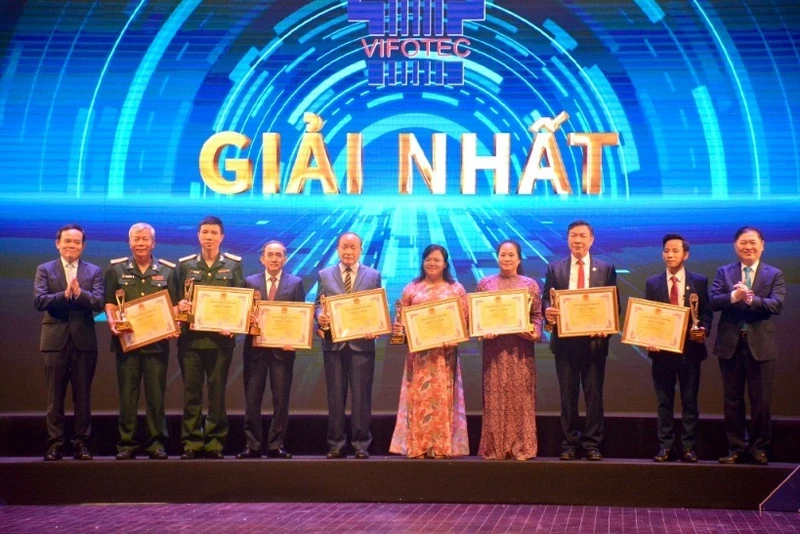 Deputy PM Tran Luu Quang and Dr. Phan Xuan Dung present the first prizes to outstanding authors and groups of authors.