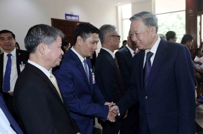 State President To Lam (R) meets Vietnamese Embassy staff and representatives of the Vietnamese community in Laos (Photo: VNA) 