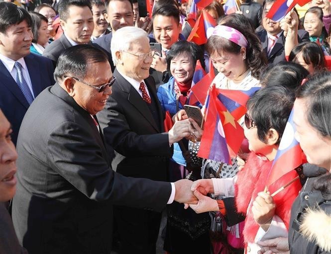 Party General Secretary Nguyen Phu Trong and General Secretary of the Lao People's Revolutionary Party and President of Laos Bounnhang Vorachith with the people of Hanoi in the morning of December 19, 2017 (Photo: VNA) 