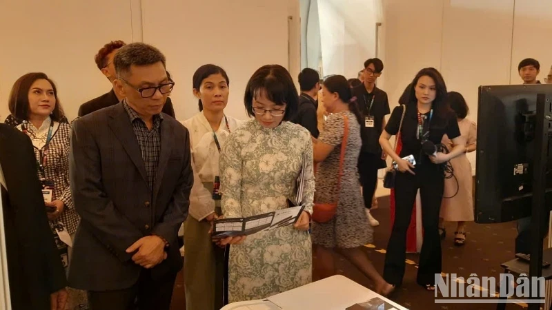 Vice Chairwoman of the municipal People’s Committee Tran Dieu Thuy (in Ao Dai - Vietnamese traditional long dress) visits the booths at the Mega Us Expo 2024. (Photo: NDO)