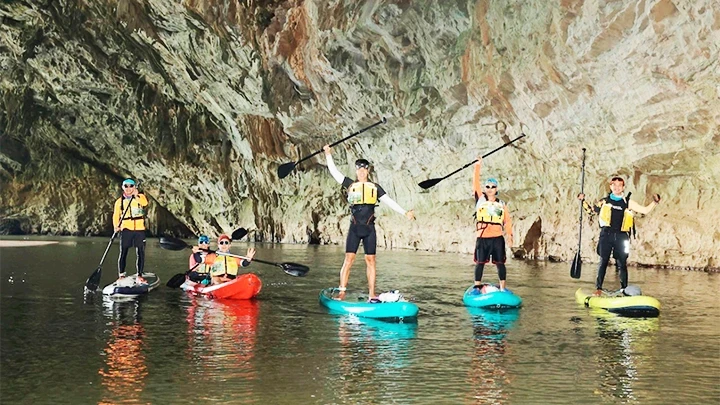 Vietnamese tourists experience a cave and SUP paddling tour at Ba Be Lake. (Photo: UMOVE ADVENTURE)