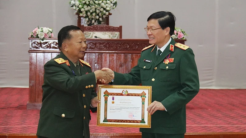 General Chansamone Chanyalath, Deputy Prime Minister and Minister of National Defence of Laos, on behalf of the Lao Party and Government, presents the first-class Labour Order to Lieutenant General, Associate Professor, Dr. Nguyen Xuan Kien, Director of the Vietnam Military Medical University.