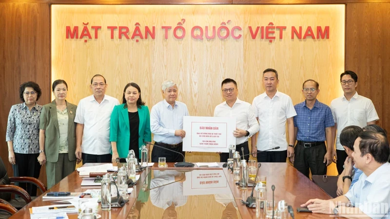 Editor-in-Chief Le Quoc Minh hands over the donation collected from the newspaper's officials, reporters, editors, and employees. (Photo: SON TUNG)