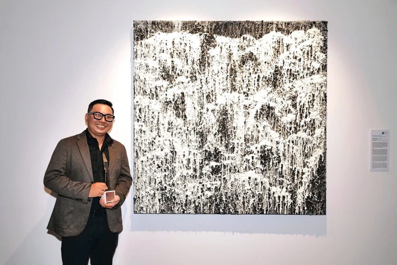 Painter Nguyen Viet Cuong and his winning painting.