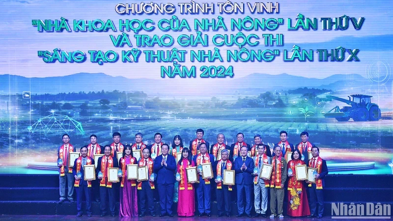 Politburo member Nguyen Trong Nghia and Chairman of Vietnam Farmers’ Association Luong Quoc Doan present the “scientists of farmers” titles to the outstanding individuals.