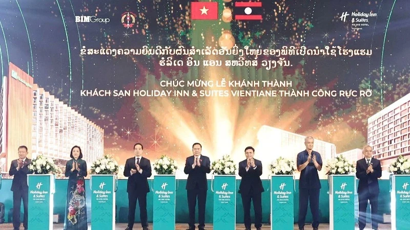 National Assembly Chairman Tran Thanh Man and his Lao counterpart Saysomphone Phomvihane, and other delegates, participated in the ribbon-cutting ceremony for the Holiday Inn & Suites Vientiane. (Photo: THONG NHAT)