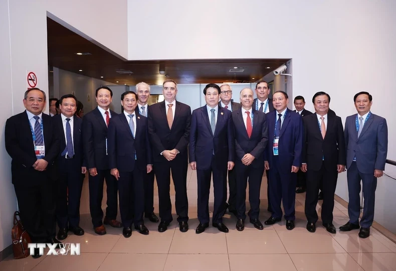 State President Luong Cuong (fifth from right) posing for a photo with leaders of major Peruvian businesses, and Vietnamese officials (Photo: VNA) 