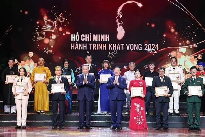 Party General Secretary To Lam (third from left, front row) and Politburo member, Secretary of the Party Central Committee and Chairman of the Party Central Committee's Commission for Information and Education Nguyen Trong Nghia (fourth from right, front row) present Certificates and Emblems to honour 25 typically outstanding models nationwide in studying and following President Ho Chi Minh's thought, morality and style. (Photo: VNA)