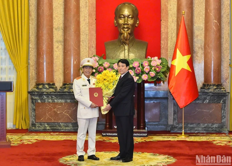 State President Luong Cuong hands over a decision on promoting Le Quoc Hung, member of the Party Central Committee and Deputy Minister of Public Security, from the rank of Lieutenant General to Senior Lieutenant General. (Photo: NDO)