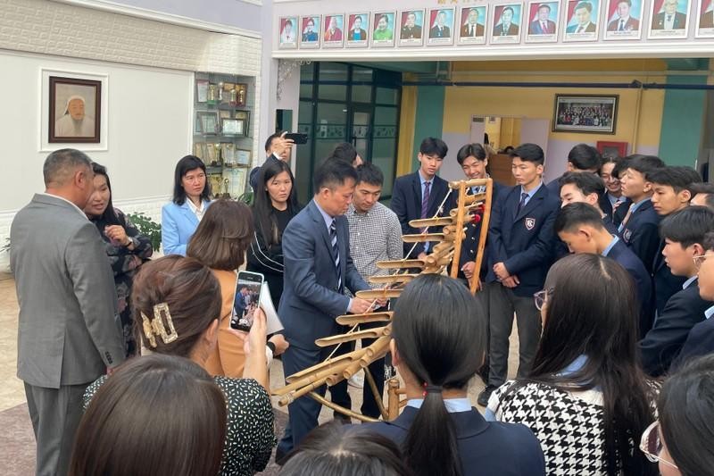  Ambassador Doan Khanh Tam demonstrates T'rung playing techniques to teachers and students at the school. (Photo: Embassy of Vietnam in Mongolia)