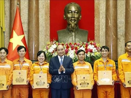 President Nguyen Xuan Phuc (centre) presents gifts to outstanding electricity workers in Hanoi on October 18. (Photo: VNA)