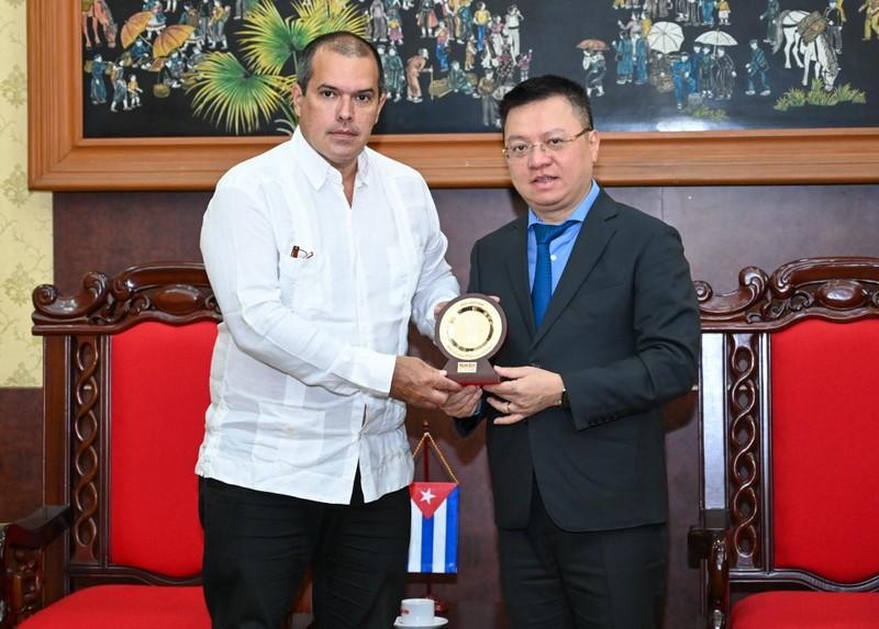 Editor-in-Chief of Nhan Dan (People) Newspaper Le Quoc Minh presents a souvenir to the Luis Enrique González Acosta, President of Prensa Latina News Agency. (Photo: DUY LINH)