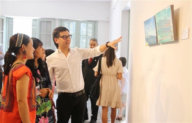 Mexico's well-known painter Diego Rodarte introduces his paintings to visitors. (Photo: VNA)