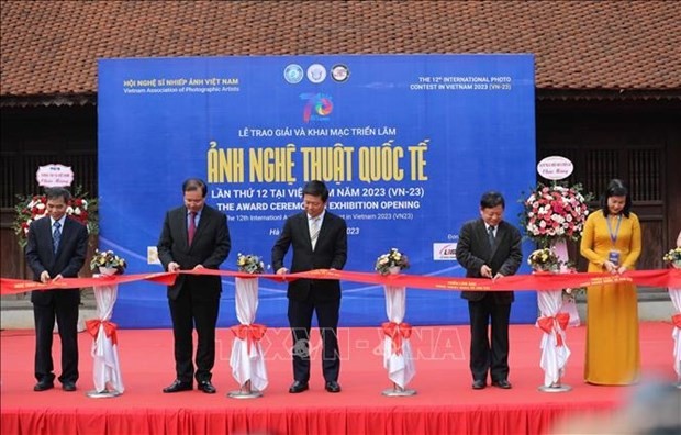 Participants cut a ribbon to launch the exhibition (Photo: VNA) 