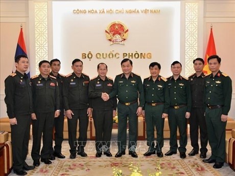 Vietnamese Deputy Defence Minister Sen. Lt. Gen. Hoang Xuan Chien (5th from R) shakes hands with Colonel Thiem Homsan, head of the Department of Chemistry under the General Staff of the Lao People’s Army, at the meeting (Photo: VNA)