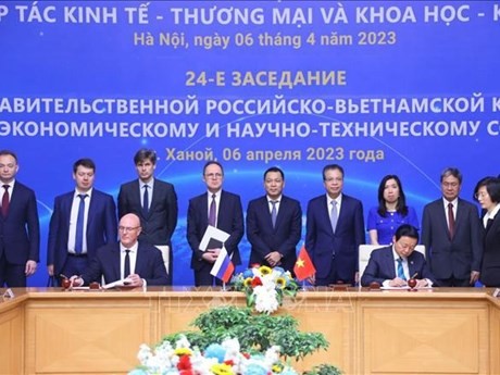 Deputy Prime Minister Tran Hong Ha (R) and his Russian counterpart Dmitry Chernyshenko sign the minutes ò the meeting (Photo: VNA)