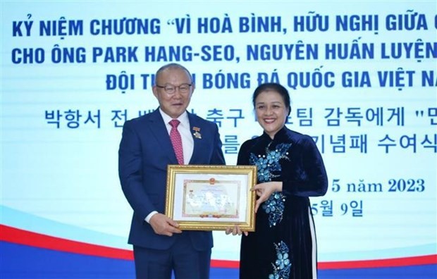 Ambassador Nguyen Phuong Nga (right) presents the insignia to coach Park Hang-seo. (Photo: VNA)