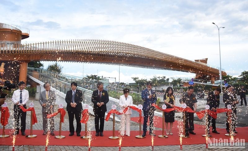 Delegates cut the ribbon to inaugurate the pedestrian bridge on July 1. (Photo: ANH DAO)