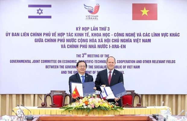 Vietnamese Minister of Science and Technology Huynh Thanh Dat (L) and Israeli Minister of Economy and Industry Nir Barkat show the signed minutes of the third meeting of the Inter-Governmental Committee in Hanoi on August 16. (Photo: Vietnam Government Portal)