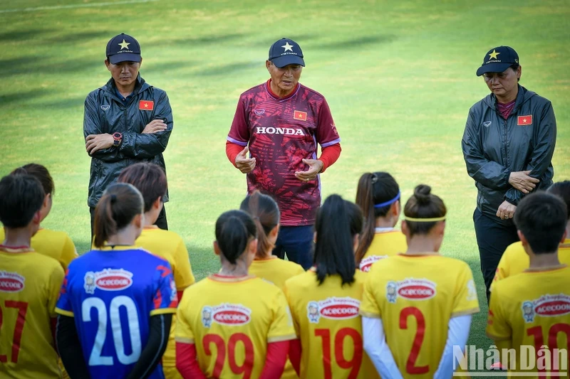 Head coach Mai Duc Chung and female football players in a training session. 