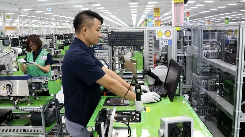 Workers of Samsung Electronics Vietnam Company operate the system of manufacturing and assembling electronic components.