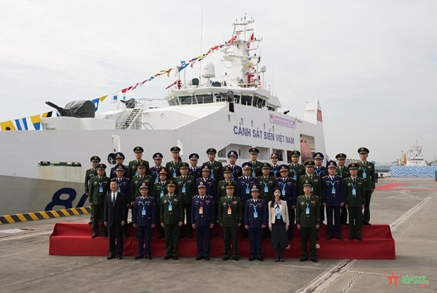 Vietnamese and Chinese delegate pose for a photo in front of Vessel CSB 8002 (Photo: qdnd.vn)