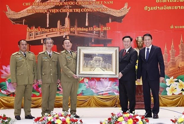 NA Chairman Vuong Dinh Hue (second, right) presents a gift to the Academy of Politics of the Lao People's Public Security. (Photo: VNA)