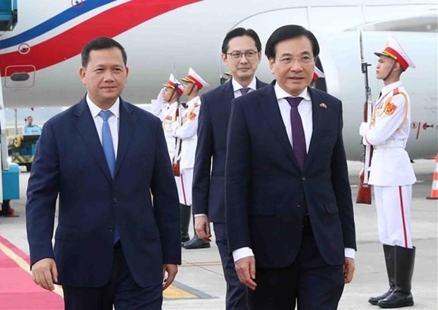 Cambodian PM Samdech Moha Bovor Thipadei Hun Manet (left) is welcomed by Minister - Chairman of the Government Office Tran Van Son (front, right) at Noi Bai International Airport on December 11 morning. (Photo: VNA)