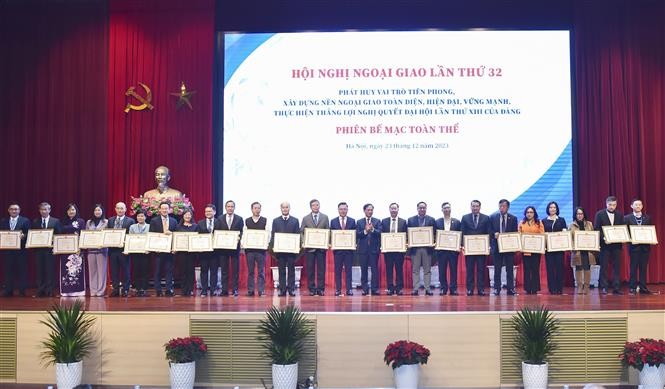 Foreign Minister Bui Thanh Son presents certificates of merit to individuals and collectives with outstanding performance in implementing their diplomatic tasks (Photo: VNA)