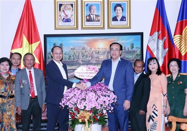 Lieut. Gen. Nguyen Van Nam, Commander of the Ho Chi Minh City High Command (fourth, left) presents flowers to Cambodian Consul General in HCM City Chan Sorykan on the occasion of the January 7 Victory (Photo: VNA)