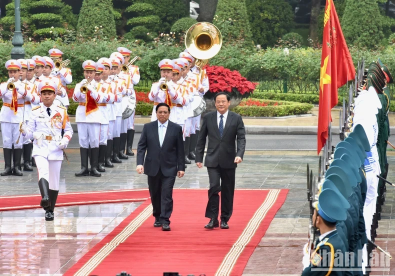 PM Pham Minh Chinh (L) and his Lao counterpart Sonexay Siphandone review the guard of honour at the welcome ceremony in Hanoi on January 6 morning.