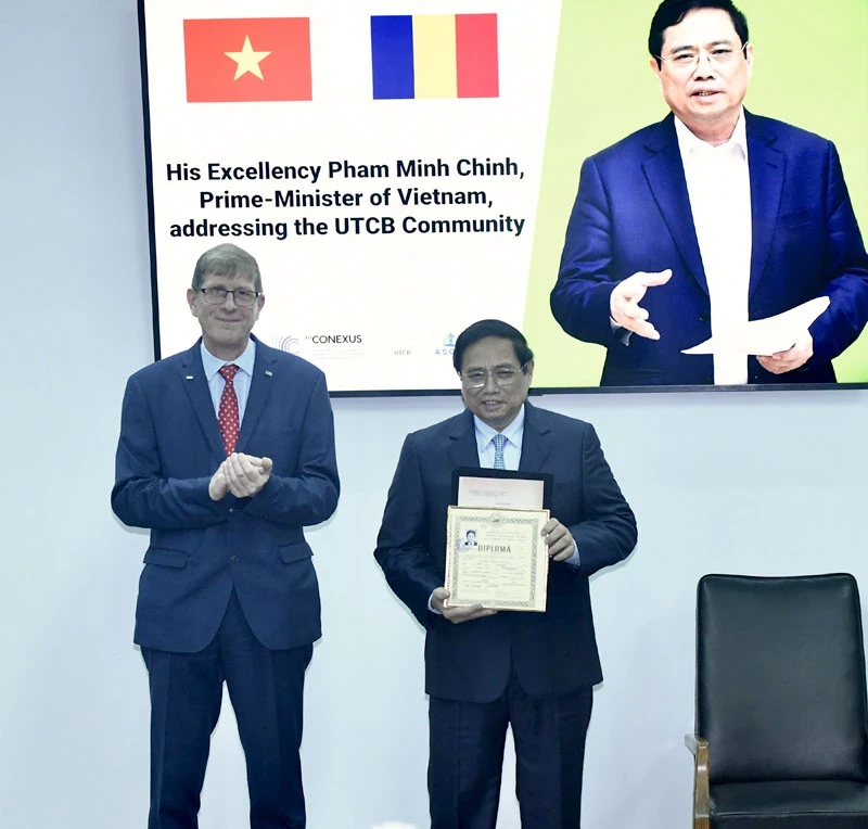 PM Pham Minh Chinh receives his student record from the UTCB's rector (Photo: VNA)
