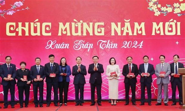 National Assembly Chairman Vuong Dinh Hue (sixth, right) extends New Year wishes to officials and employees of the NA Office on February 15. (Photo: VNA)