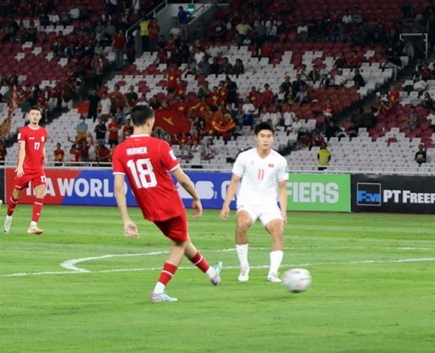 Nham Manh Dung (11) and teammates struggle against a strong Indonesia side with naturalised players such as Christian Hubner (18) (Photo: VNA). 